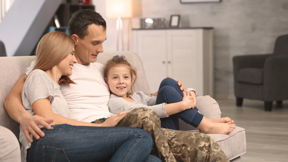 Military father sitting at home with family