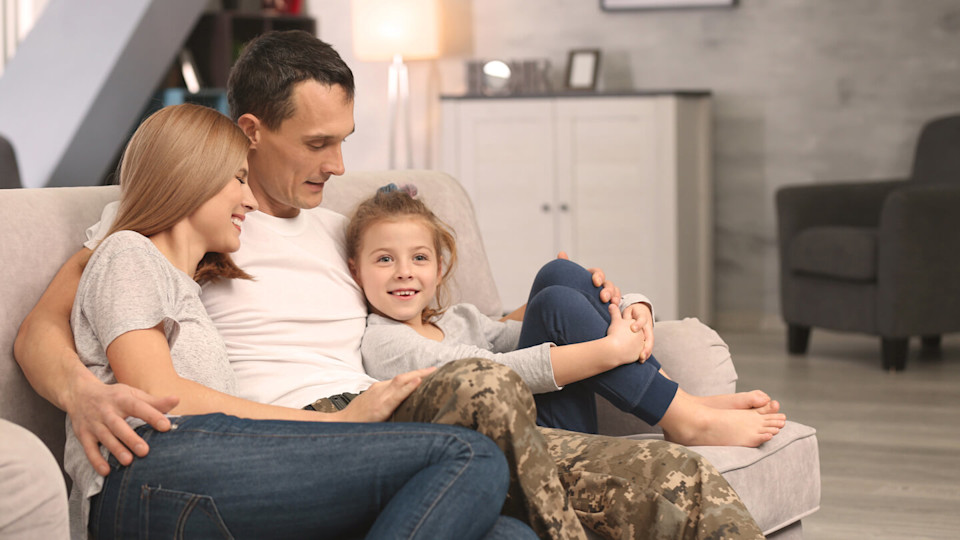 Military father sitting at home with family