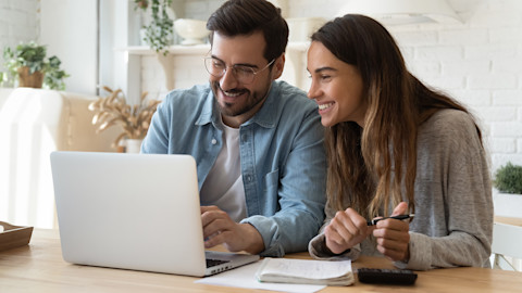 Couple smiling at laptop