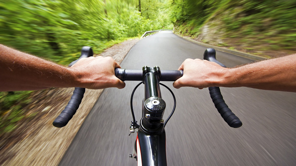 Newsroom - Man holding bike handles on a road 