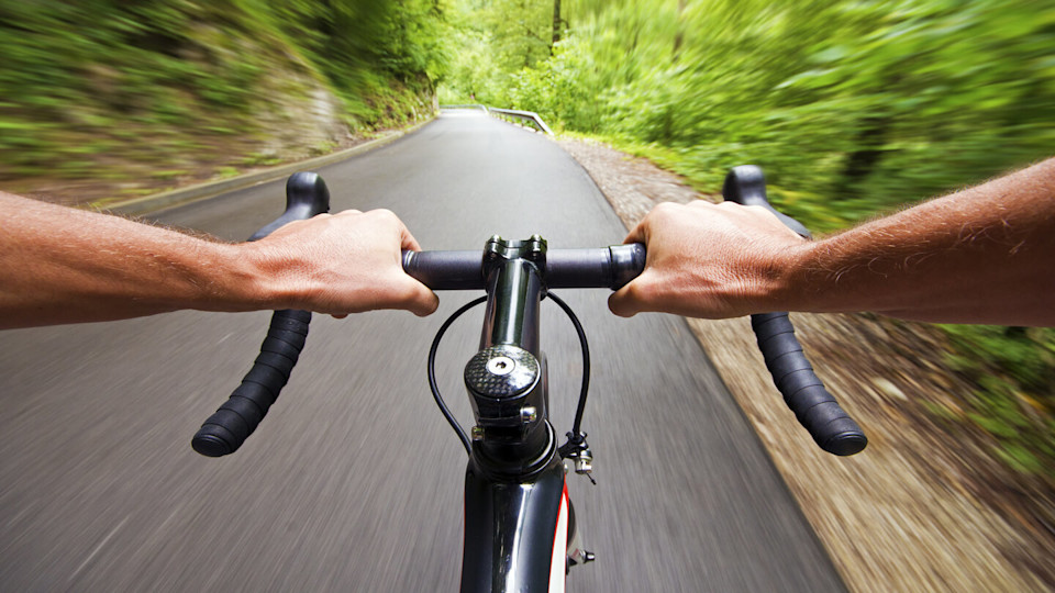 Man holding bike handles on a road
