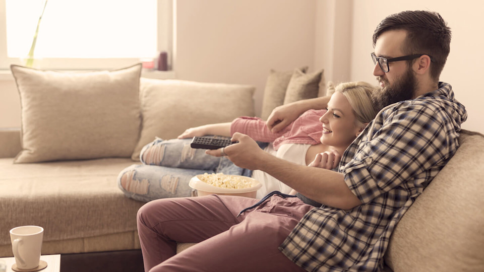 Young couple watching a movie and having popcorn