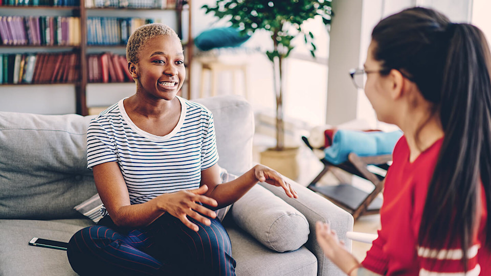 Woman chatting to friend on sofa