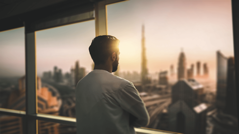 Man looking out of window in Dubai