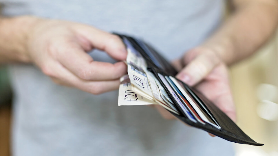 Newsroom - Man getting money out of wallet