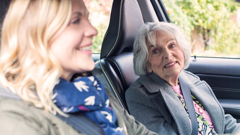 Woman and elderly passenger in car drive driving