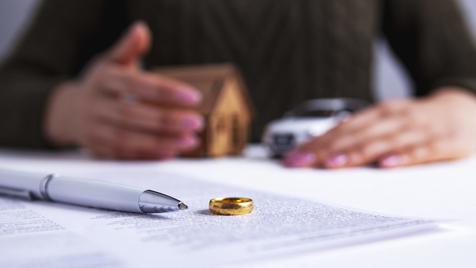 Wedding ring off and woman holding house and car 