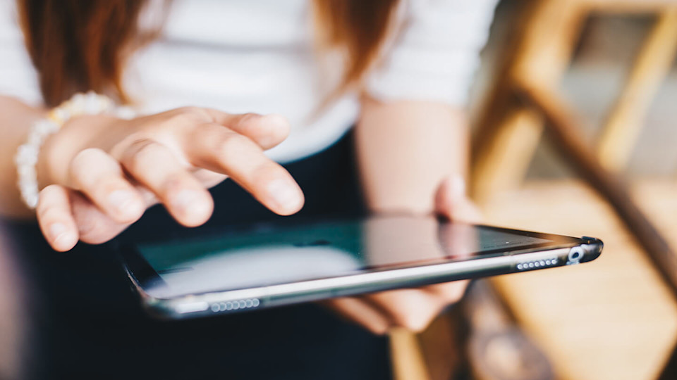 Woman typing on tablet
