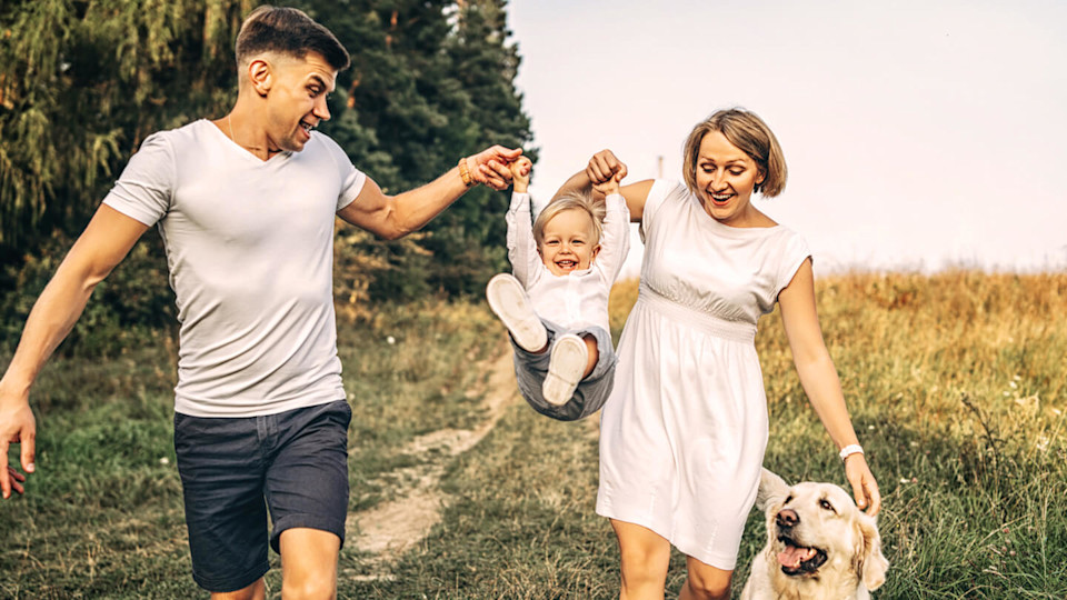 Young family with child and a dog walking outdoors