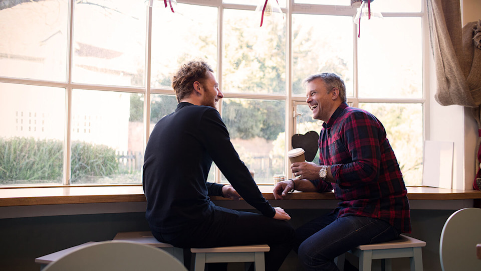 Two friends chatting by the window with a coffee