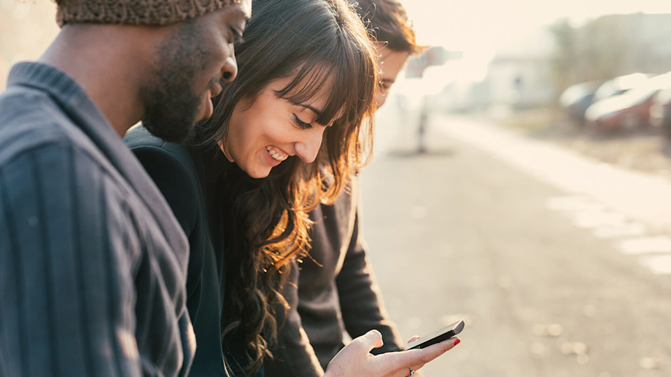 Friends laughing looking at phone