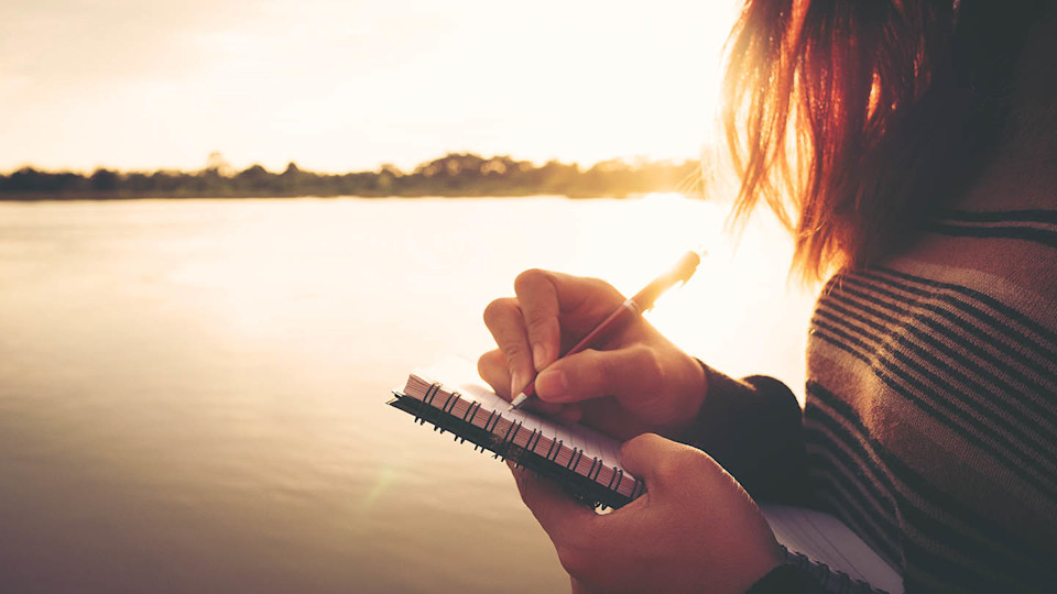 Newsroom Imagery - woman writing by a lake 