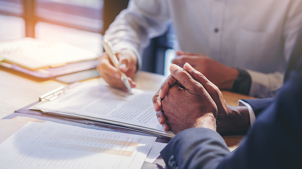 Businessman reading documents at meeting, business partner considering contract terms before signing checking legal contract law conditions