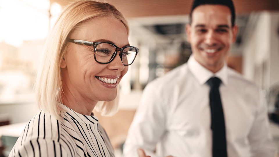 Smart woman and man in suit smiling