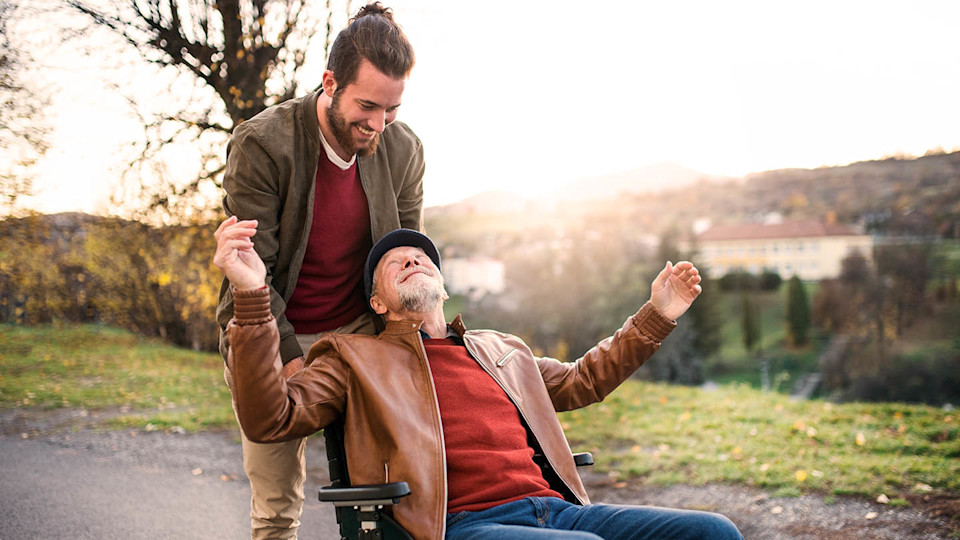 Carer looking after man in wheel chair