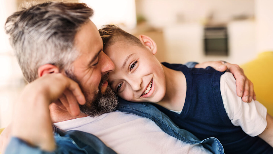 Father slouching and embracing son