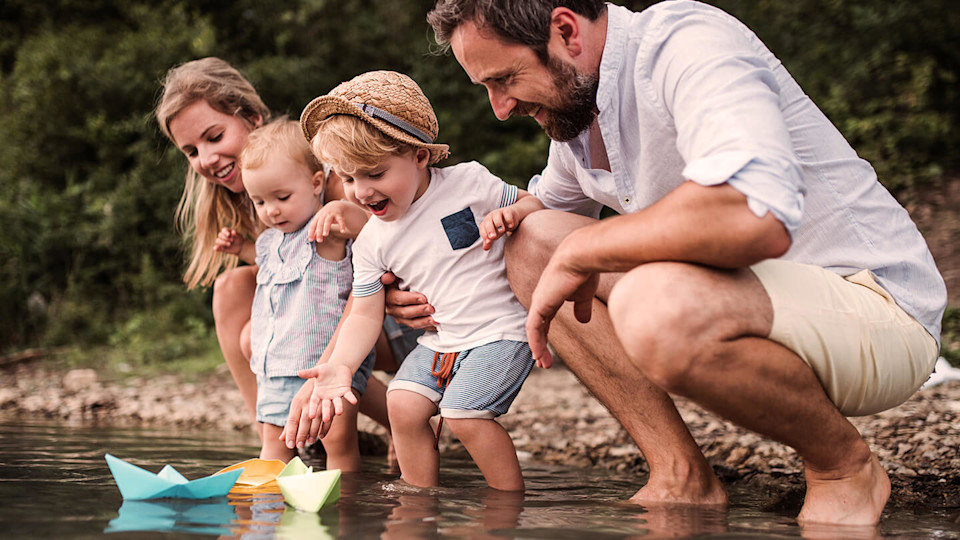 Young family with two children playing in the water