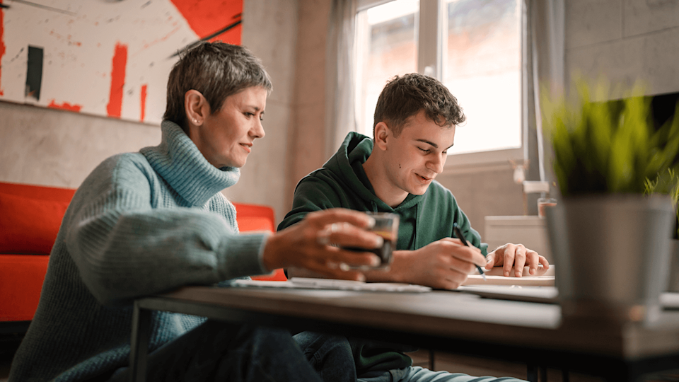 teenage boy with mother at table