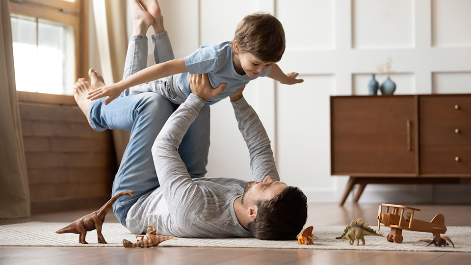 Man lifting child up in air