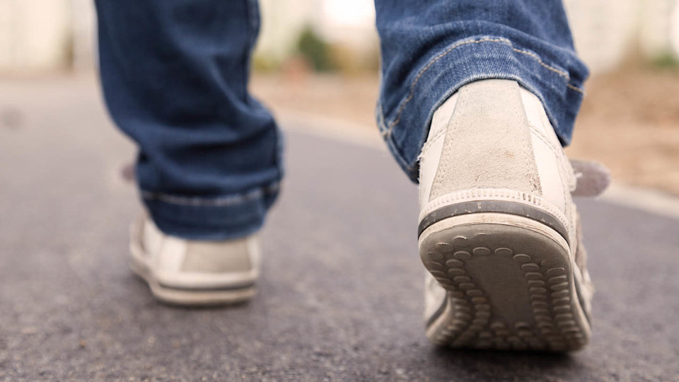 Newsroom - man's feet walking on pavement