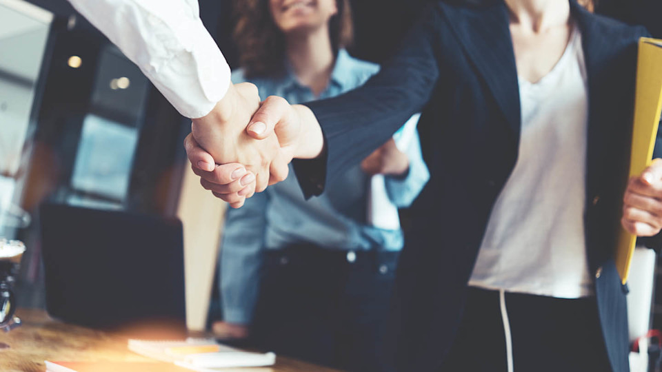 Newsroom office workers shaking hands