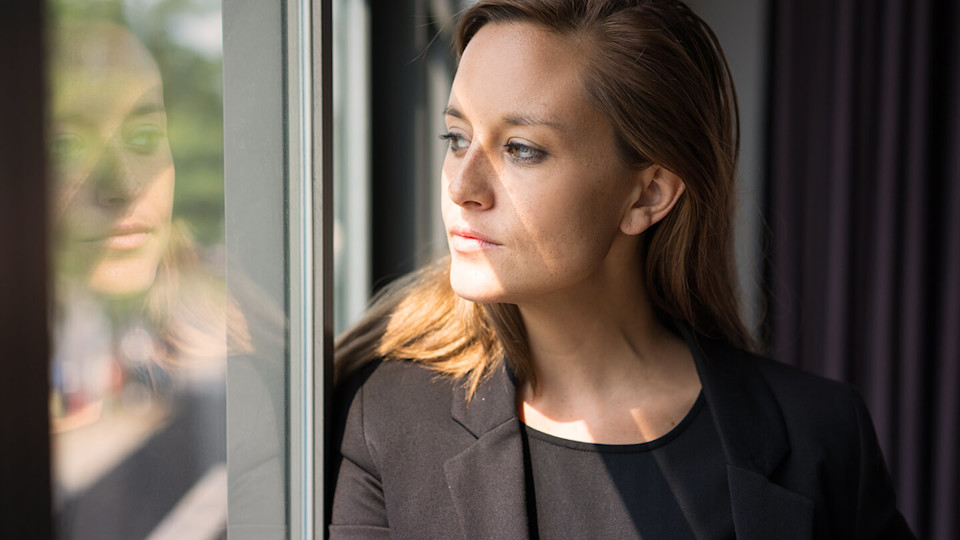 Young woman looking thoughtfully out of a window