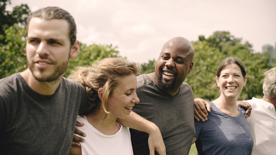 Group of smiling people hugging each other in the park