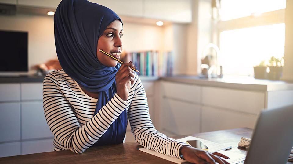 Woman sat working at kitchen table