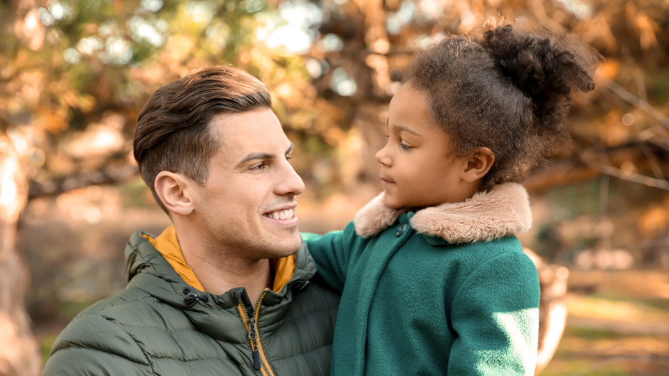 Young man and little girl outdoors on a sunny day