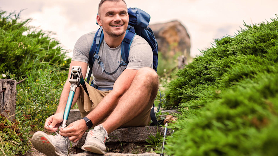 Man with prosthesis tying his shoelace