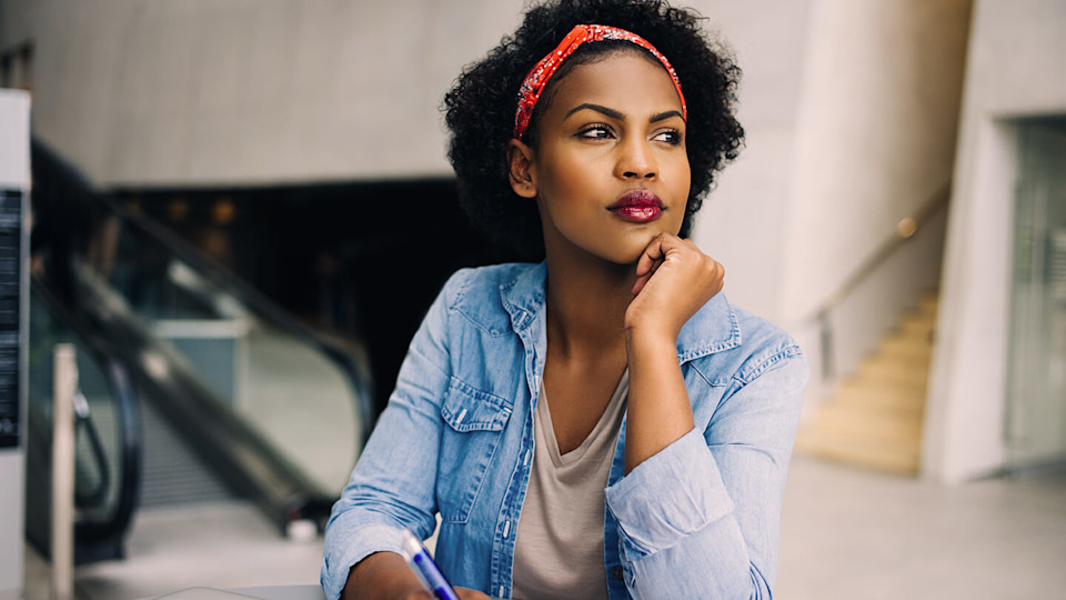 Contemplative woman writing in notepad