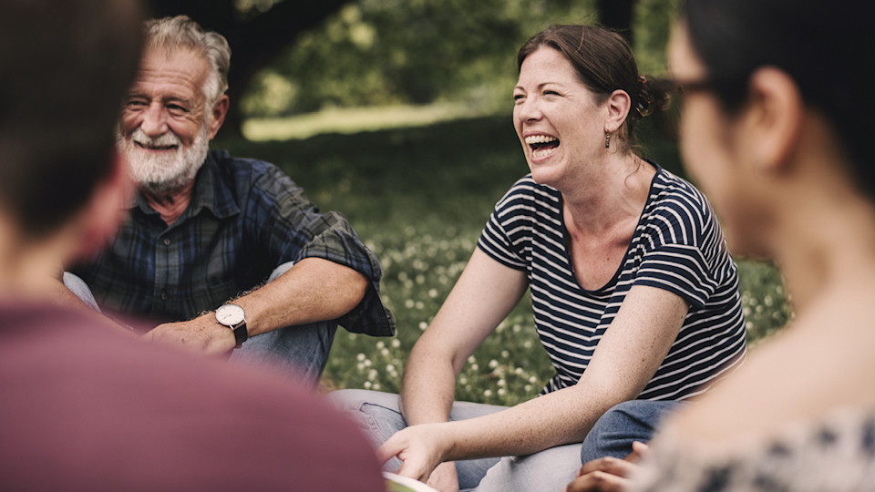 Middle aged friends sat in park