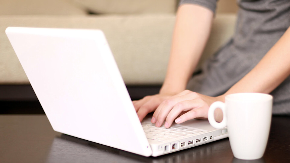 Laptop and cup on coffee table