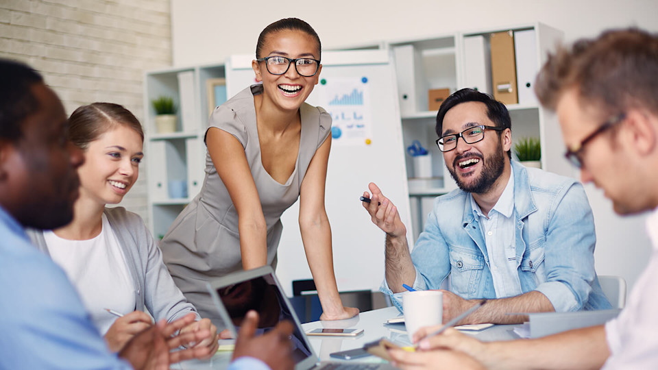 employees sitting round table smiling