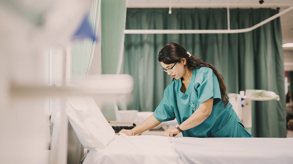 Nurse making the bed at a hospital