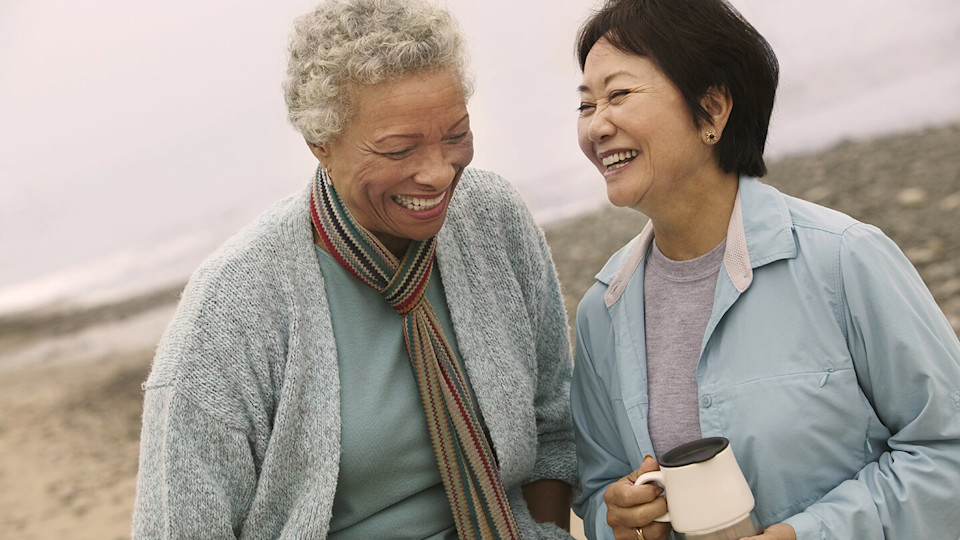 Happy mature women laughing on a beach