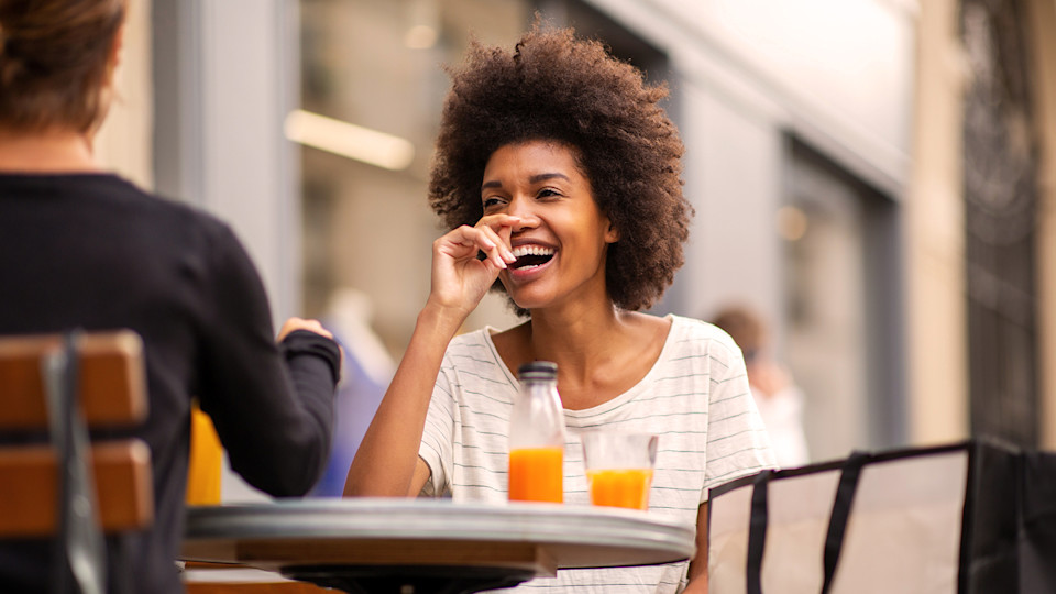 Woman drinking orange juice outside