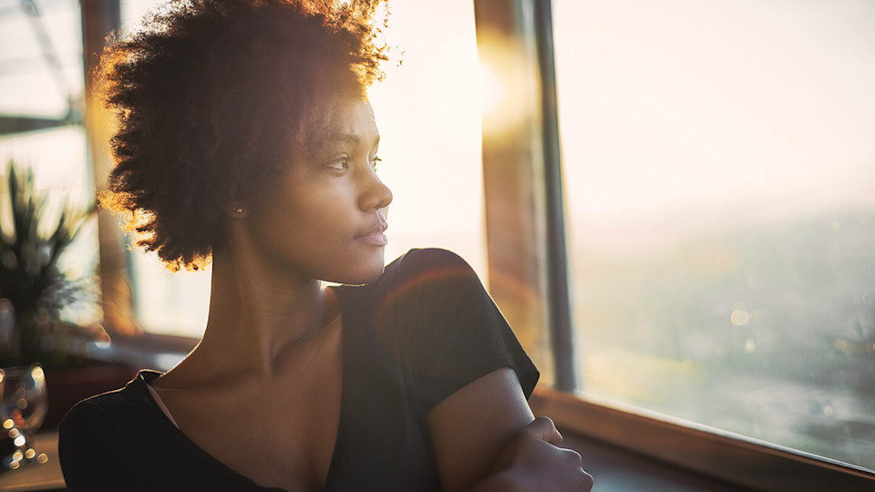 young woman gazing out of window