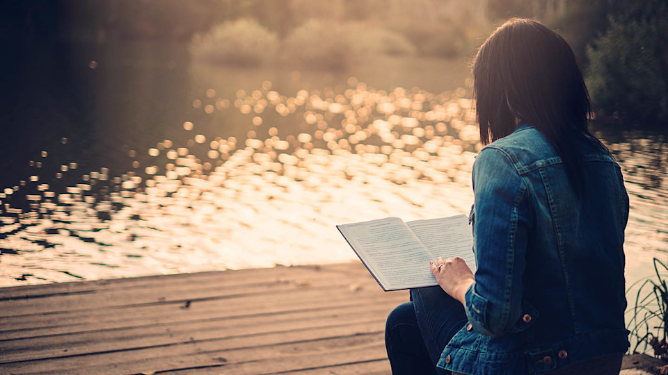 Newsroom Image - woman reading book by lake