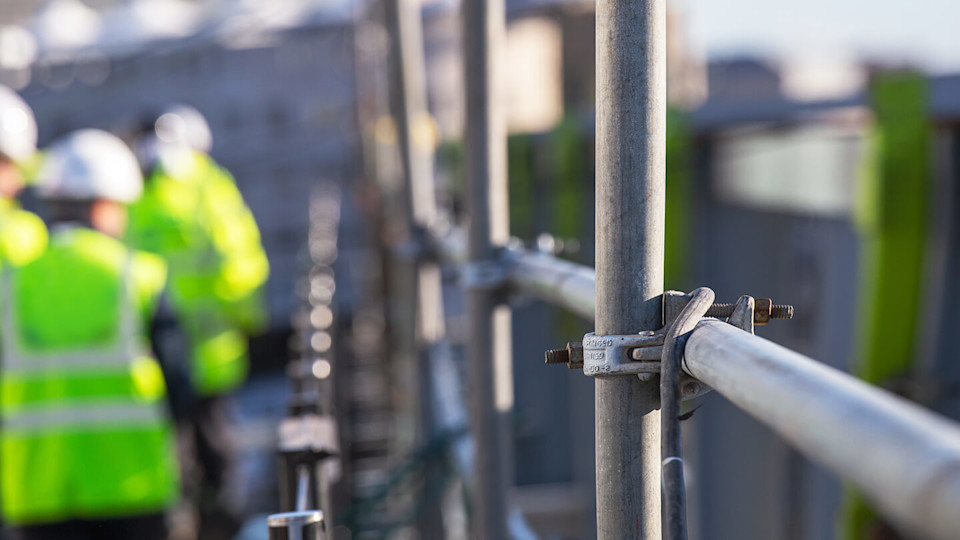 Scaffolding building site and high vis vests with hard hats