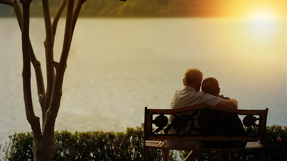 Newsroom - older couple on bench by lake
						