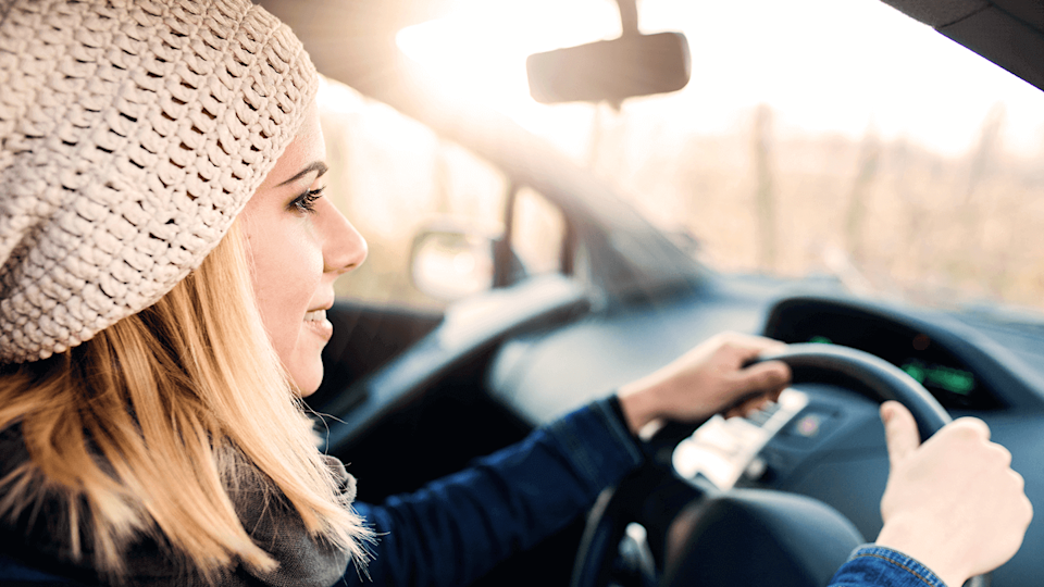 Woman in pink hat driving car