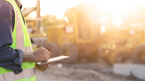 man working in construction writing on pad