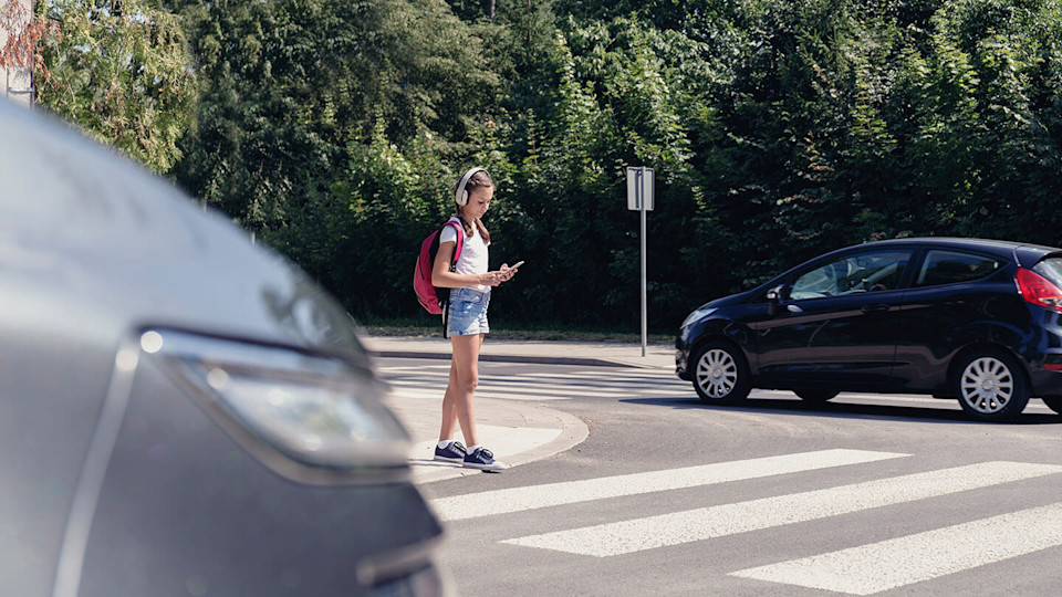 Young girl crossing at zebra crossing 
	road 
	traffic